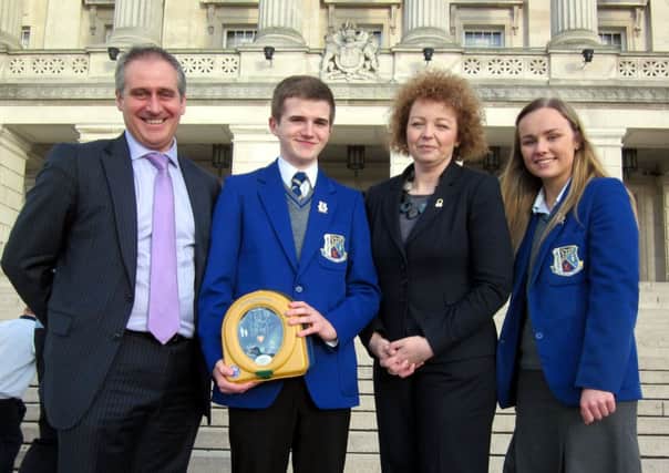St Killian's College prinicpal Mr Jonny Brady, headbBoy Ronan McAuley and head girl Hannah McIlwaine are pictured receiving the defibrillator on the steps of Stormont from Department of Culture, Arts and Leisure Minister Carál Ní Chuilín. INLT 50-610-CON