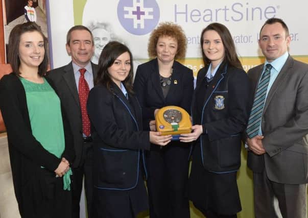 St. Louis Grammar School pupils, Siofra O'Mullan and Niamh Laverty, with school representatives, Marese Mulligan and Adrian Quinn, receive their defibrillator from Sports Minister Carál Ni Chuilín and Declan OMahoney, Chief Executive of defibrillator manufacturer, HeartSine Technologies, at a special ceremony in Stormont.