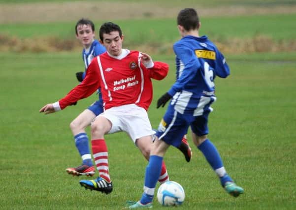 Carniny U-15 player Thomas Campbell tries to tackle his Coleraine opponent. INBT51-267AC