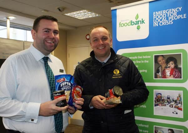 Connor Duncan of Barclays Bank pictured along with customer Richard Campbell donating to their food bank collection. INBT51-274AC