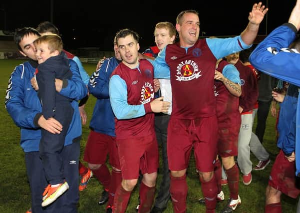 Gary Simpson (far left) celebrating with his players after Newbuildings United defeated Institute, in the North West Senior Cup Final.