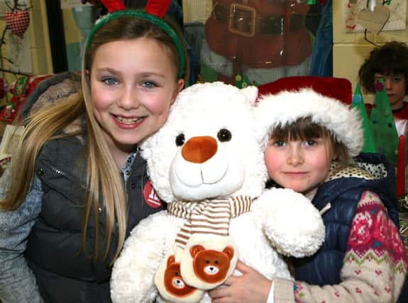 Christmas cuddles from Olivia Symington (7) and Katie Wallace (6) at the fair in the Donkey Sanctuary. INNT 50-050-FP