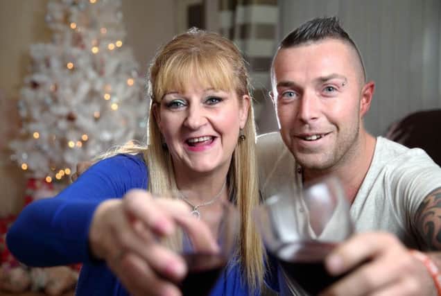 SPIRIT OF CHRISTMAS: Lesley Anna Barber-Campbell, who had her Christmas money stolen while out shopping, and Jeff Morrison, who organised a collection for her, raise a glass to the many Lisburn traders who helped save Lesley's Christmas by making generous donations. US1351-550cd Picture: Cliff Donaldson
