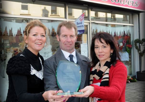 Ian Henry President of Magherafelt Chamber of Commerce with Maria McMullan and Donna Birt of House of Flowers Rainey Street who took third place in the Chamber's Christmas best dressed window competition.INMM5213-331SR