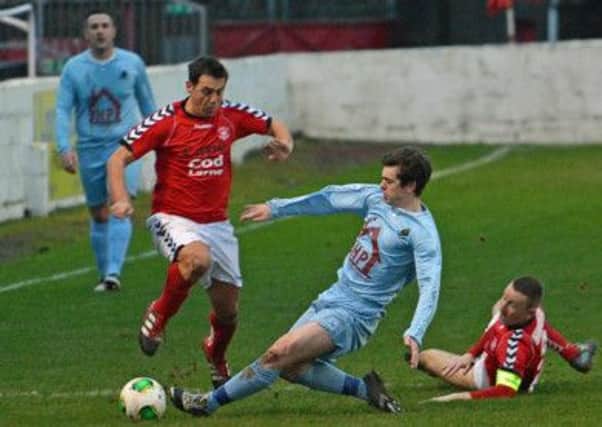 Institute's Gary Henderson slides in to win the ball during their game at Larne, on Saturday. INLT 52-005-PSB
