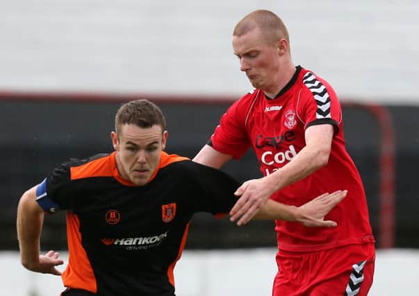 Carrick's Aaron Harmon in action against Larne's Niall McAllister when the two sides last met in October.
