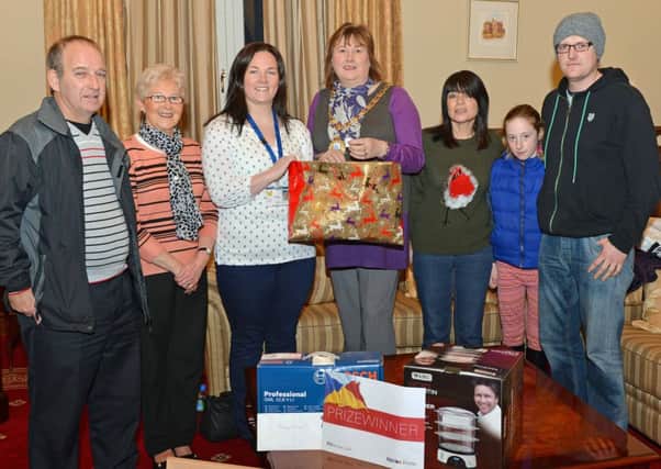 Mayor of Larne Maureen Morrow picks the winning ticket in the PIPS Larne Christmas ballot with members Peter McAllister,Anne Kelly,Stephanie Bird,Carlee Letson and Davy Currell with his daughter Hannah,the winner of the ballot was Mr George Sloan. INLT 52-006-PSB