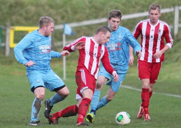 Wakehurst defender Gavin Gilmore attempts to clear his lines during Saturday's win at Portstewart, as team-mate Chris Rodgers looks on.