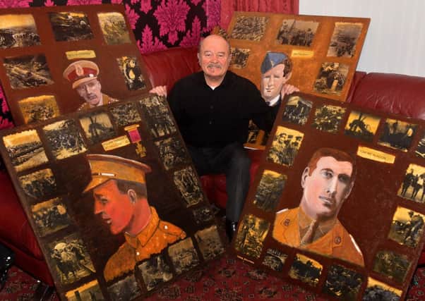 Denis McAlinden, from Castor Bay Road, with his paintings of local war heroes. INLM02-211.