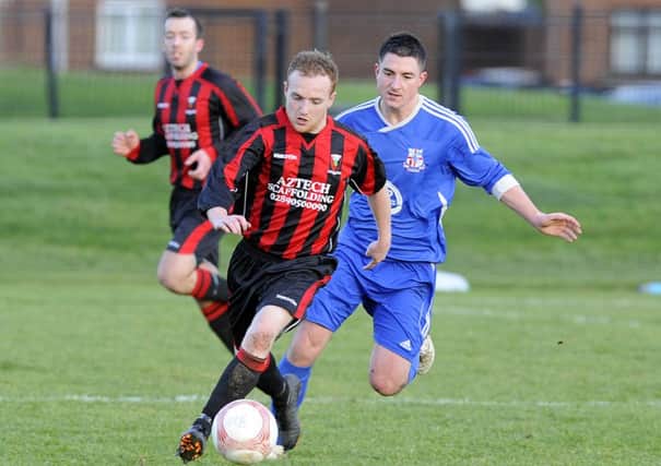 Rathfern's Richard Marks keeps a close watch on Grove United's Ryan Large. Photo: Philip McCloy