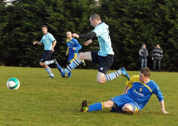 A Randalstown Sky Blues player hurdles the challenge of a Michelin opponent during Saturday's Division One match. INAT 03-904H