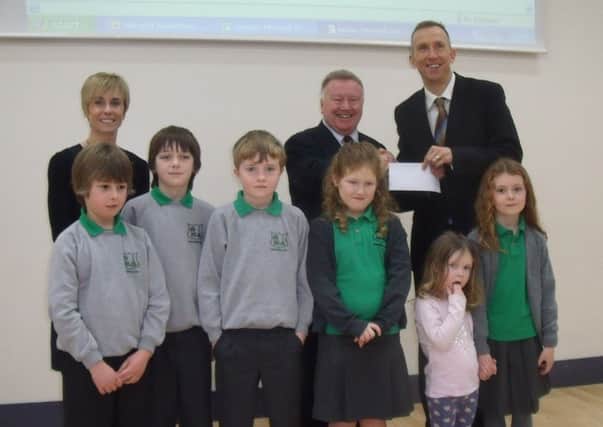 Greenisland Primary School Principal Brian Stirling hands over a cheque for £3000 to Roddensvale School Principal John Madden. The money was raised during a sponsored aerobics morning. With them are Mrs Roy and some of the Greenisland Primary School pupils. INLT 03-802-CON