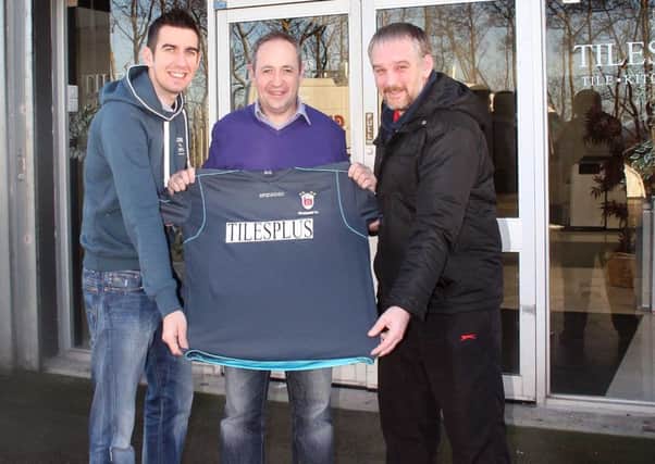 Lindsay O'Neill from Tiles Plus on the Taughey Road, Ballymoney, presents a new strip to Balnamore FC officials Nivky Tweed (left) and Geoffrey Wilmont. Picture by Sammy McMullan.INBM03-15-14 263F