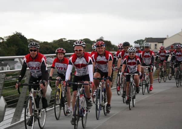Foyle Cycling Club members cycle over the Peace Bridge.