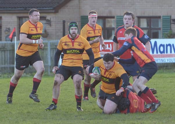 Carrick's Ryan McGonigle tries to escape the clutches ofhis opposite number. Photo: Peter Rippon.