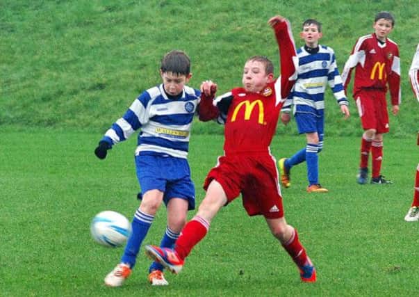 A Carniny Youth U-13 player nicks the ball away from a Northend opponent during Saturday's NIBFA Cup tie. INBT 04-915H