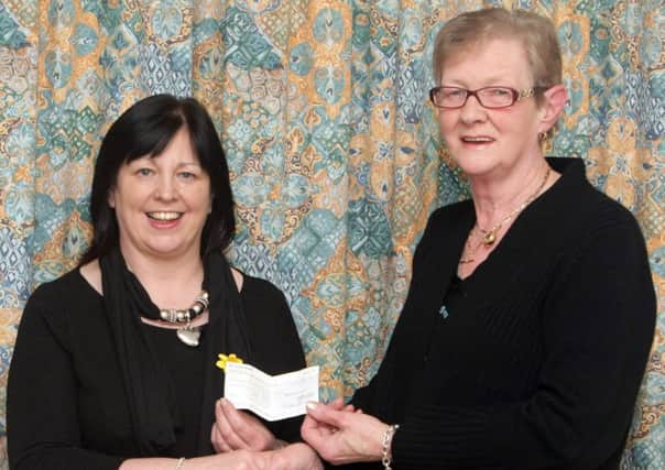 'THREE'MENDOUS. Betty Caldwell (right), pictured handing over a cheque for £300 to Marie Curie Nurse Eleanor Doherty on Saturday night at the finals of the Dunloy Presbyterain Indoor Bowling Club's bowling tournament. Betty raised the money through a Fireside Quiz.INBM4-14 032SC.