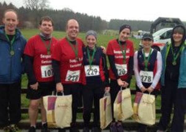 Members of Seapark AC proudly displaying their medals after a very mucky 10k trail race in Gosfrod Forest Park on January 18.