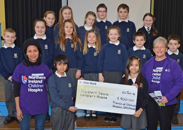 Maria Jones (left) with her son William and daughter Olivia and pupils from Whitehead Primary School present a cheque for £900 to Catherine O`Hara,Community Fund Raiser with the NI Childrens Hospice,the money was raised by this group of children and their parents doing a sponsored swim at Whitehead on New Years Day. INCT 04-033-PSB