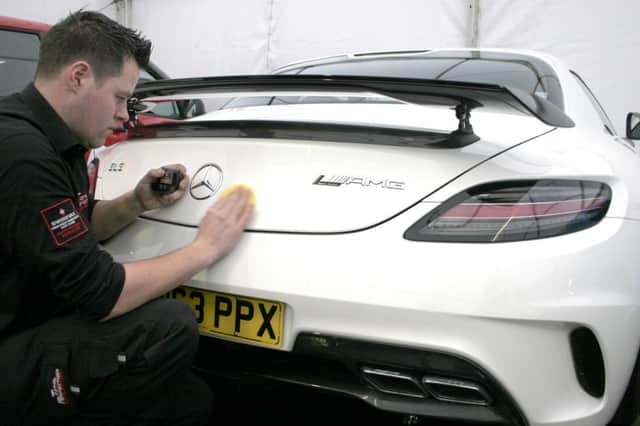 Managing Director Mark Smiley cleaning one of the cars at the show. INBM05-14