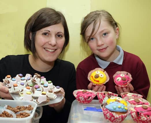 SWEET TREAT. Teacher at Carrowreagh PS Karen McIlroy, pictured with fundraiser Rossanna and some of the treats on sale on Thursday.INBM5-14 008SC.