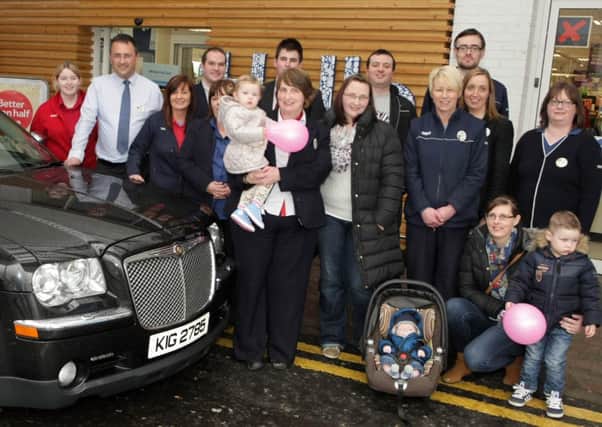 GRAND EXIT. Service Line Manager Ann Kane (holding wee girl), who has retired from Tesco after a total of 46yrs, pictured leaving her work in style on Wednesday in a limo driven by Trevor watched by family, friends and work colleagues including Manager Derek Loughlin (2nd left).CR5-107SC.