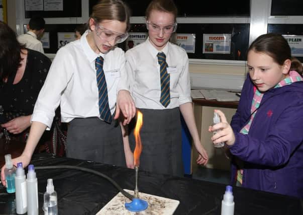 Visitor Karina takes part in an experiment with students Erin and Jessica in the Science department during the Slemish College Open Night. INBT 06-111JC