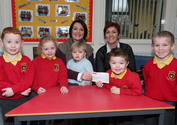 Principal of Ballykeel Primary School Mrs Sheeran presents a cheque for £800 (proceeds of a non uniform day held in the school on January 24th), to Rachael Kirk and her son Joshua while looking on are pupils Charlie Gregg, Jessica Magill, Joel Gilchrist and Matthew McDowell. Rachael, her husband and family are taking part in a six month mission to the Philippines. INBT 06-102JC