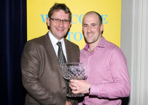 Sean O'Connell, captain of Clooney Gaels hurling team, receives the Team of the Year award from John Millstead of sponsors Michelin. INBT06-221AC