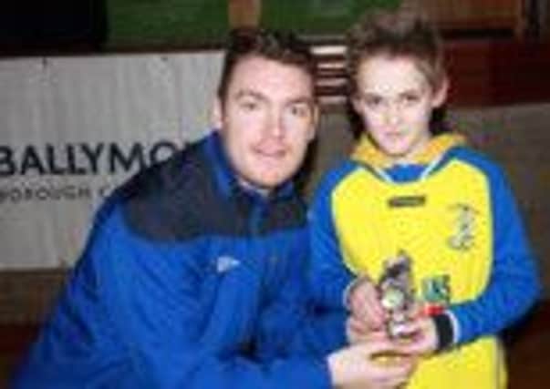 Rasharkin's Christopher McNally receives his Player of the League award from Ballymoney United player Ger Gillan.