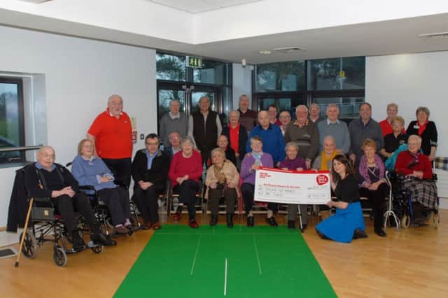 Members of the Carrickfergus Chest Heart and Stroke group present a cheque for £1,110  to Ellie Martin (kneeling front) Donor Marketing Manager with Chest Heart and Stroke NI,the group raised the money through a sponsored stroll in the Concordia Suite and will be donated to the Baby Hearts Appeal. INCT 05-038-PSB