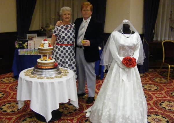 Rose and Sam Murray, who recently celebrated their 50th wedding anniversary in the Adair Arms Hotel, which was the venue of their
wedding reception in 1963, are pictured with a special cake to mark the occasion.  On display is Rose's actual wedding dress.
