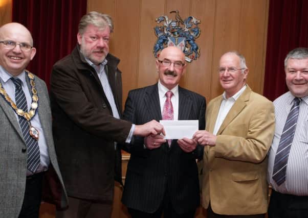 DEAR SANTA. Ballymoney's 'Black Santa' Liam Beckett (centre), pictured presenting a cheque to Alan and Tommy, who were accepting in on behalf of the Samaritains at Riada House on Wednesday night. Looking on are Mayor Cllr John Finlay and Ivor Wallace, who assists Liam during his sit-out.INBM7-14 011SC.