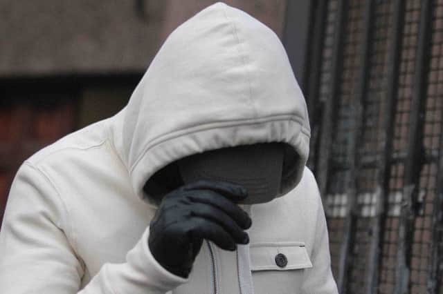 Paul Toland covers his face at Ballymena Court after both he and his wife Jennifer Toland were charged with the murder of Coleraine pensioner Bertie Acheson.PICTURE MARK JAMIESON.