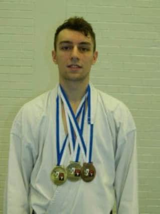 Andrew Mills proudly displays the medals he won at the World Karate Confederation International Open Championships in Munich.