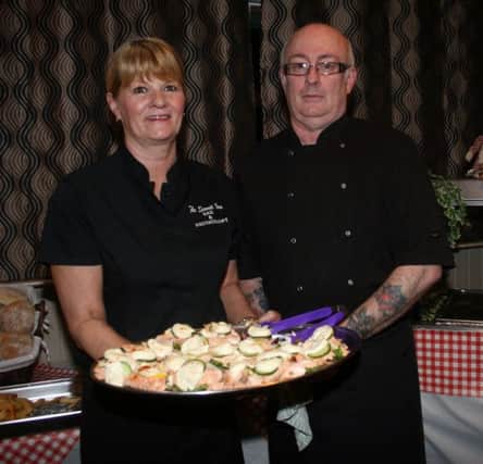Shirley McKinley and Charlie Patton with some of the delicious food served up in the Game night at the Scenic Inn where proceeds went to the charity SOLAS.INBM08-14 100F