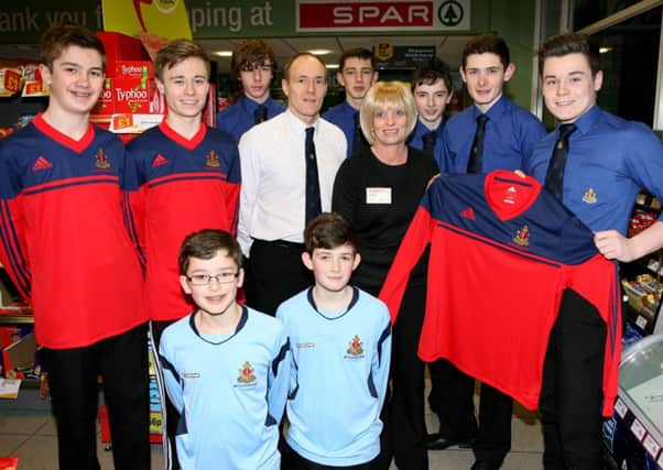 Angela Millar of Spar Broughshane presents a new sponsored football kit to Shane Gibson and members of First Broughshane Boys' Brigade. INBT08-253AC