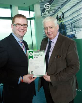 The Finance Minister presents George Kernohan of Braid Electrical Services in Ballymena with a SparkSafe certificate.