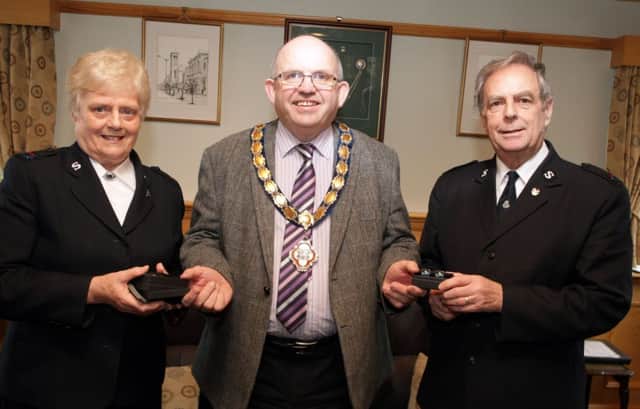 RETIRE. Mayor Cllr John Finlay presents gifts to Victor and Thelma Haslett, who have retired from Ballymoney Salvation Army after 14yrs.INBM9-14 007SC.