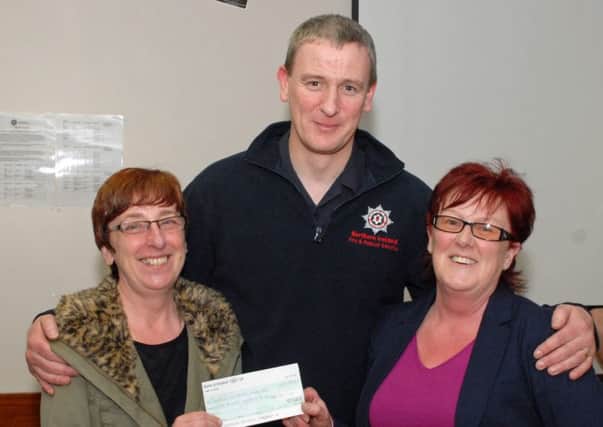 Liz Gibson and Joanne McCalmont of Playtots Nursery accept a cheque for £150 from Raymond Ferguson of Larne Fire and Rescue Service. The money was raised by the Larne crew on their annual Santa Drop. INLT 09-005-PSB
