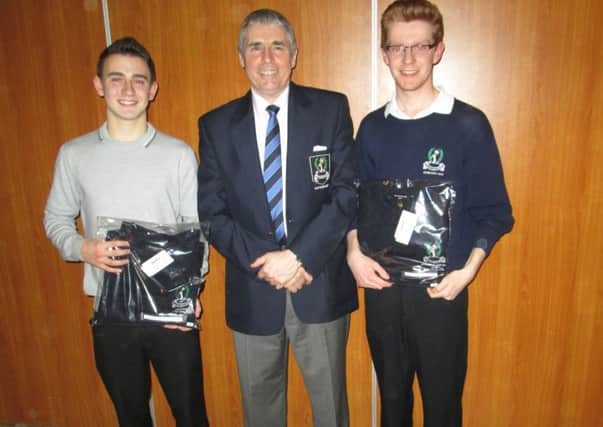 Dunmurry Golf Club captain Lawrence Patterson hands over pullovers to Ryan Trimble (Fred Daly team captain) and Peter Morgan  (Dunmurry Juvenile team captain).