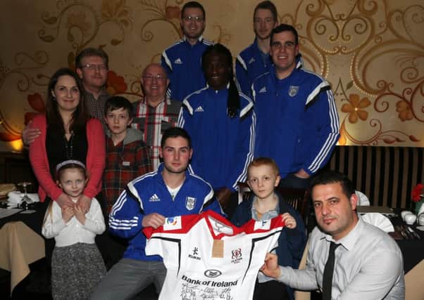 Mark Young of Ahoghill Thistle FC and Khayber Restaurant manager Mehrez (front right) present a signed Ulster Rugby shirt to Cameron Millar at a fund raising evening in the Khayber Indian Restaurant, Galgorm to raise funds to send Cameron on a dream holiday to Disneyland Paris. Included are fellow Ahoghill Thistle players, Cameron's parents Naomi and Timothy, brother Jacob and sister Rhiannan (right), his grandad Mervyn Darragh. Overall the evning raised £3000. INBT 10-110JC