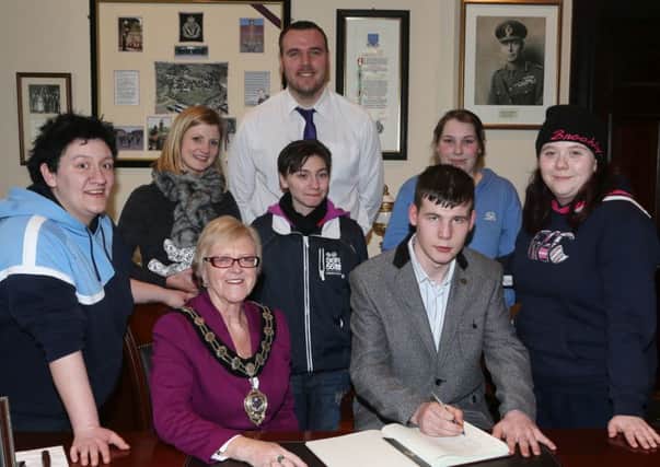 Stuart Forsythe of VOYPIC  signs the Visitors Book at a reception hosted by Mayor of Ballymena Cllr Audrey Wales in the Braid Town Hall to honour the group's Diana award which they received for their volunteering work. Also included are, L-R, Back, L-R, Ashley McIlwaine, Susan Jackson (VOYPIC staff member), Ian Black (VOYPIC Area Manager), Sarah Davis, Rosie Nicholl, Catherine Reynolds. INBT 10-109JC