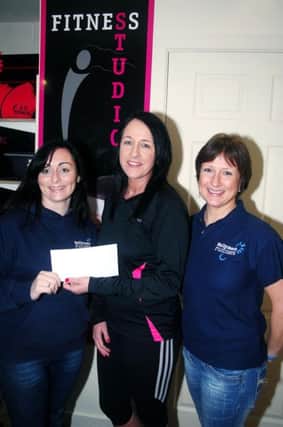 Kelly Courtney and Christine Caulfield, of the Ballymena Runners Club, are pictured receiving a cheque from Bernie Doran, B.D. Fitness, Galgorm Industrial Park; which will go towards the clubs forth coming "Bell 5 Mile" run to be held on the 8th April in aid of N.I.K.P.A.. INBT 05-804H