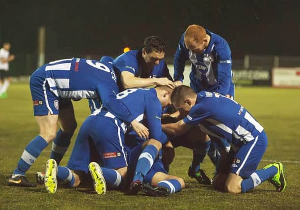 Man of the Match David McDaid is mobbed by Coleraine team-mates.