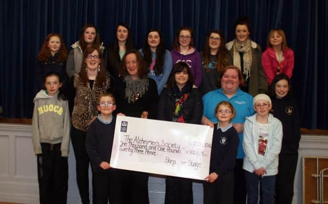Ann-Marie Moore and Sharon Neely from the Alzheimer's Society accept a cheque for £1001.23p. from members of the Step on Stage Youth Club at Dunloy Presbyterian Church hall on Monday night. The money was raised by the young people following two fund-raising events in Cloughmills and Dunloy last year. Also included are Step on Stage founders, Rebecca Calderwood and Heather Loughridge.INBM11-14 100LMM