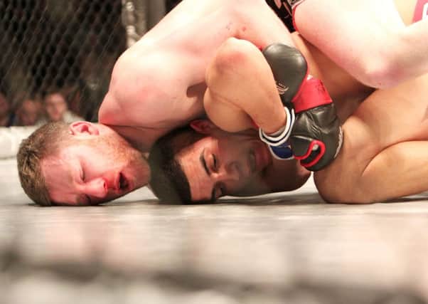 Connor White is caught in a head lock with Rowan Penderville during their fight at the Odyssey. INBT10-238AC