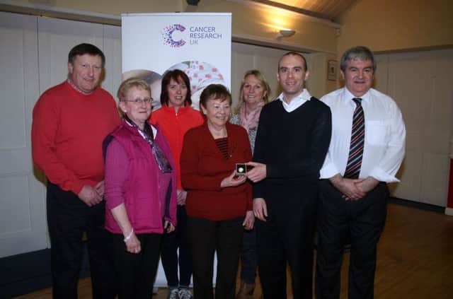 Eileen Keers, a stalwart of the Ballymoney Committee of Cancer Research UK, is presented with her 40-year medal from Mark McMahon, local fund raising manager, at the Royal British Legion, Ballymoney, last Tuesday night Also included are members of the committee, Edgar Murphy, Dorothy Hill, Debbie Tutty, June Skelton and Mervyn Ferris (chair).INBM11-14 103LMM