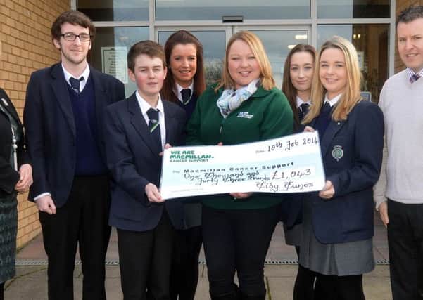 Lismore Comprehensive School pupils who are members of the school's Young Enterprise Mini Company, 'Tidy Tunes', have raised £1043 for Macmillian Cancer Support through sales of their earphone lead tidy device. Pictured at the presentation of the cheque are from left, Mrs Rosemary Lavery, acting principal, Gareth Bell, Rachel Maguinness,P.J. Magee, Stefani Mearns, fundraisin manager, Macmillan, Roisin Devlin, Aoibhinn Lennon and Mr Francis McVeigh, link teacher and mentor, Young Enterprise. INLM07-217.