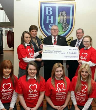 UP THE REDS. Jamie Walker, Volunteer for the British Heart Foundation N.Ireland, pictured at Ballymoney High School on Friday receiving a cheque for £465.00 from pupils Laura Fall and Melissa McNeill. The money was raised at a 'Ramp Up The Reds' event and included are H.E. Teacher Elizabeth Campbell, Principal Rodney Scott and pupils, Chelsea Gordon, Rebecca Fleming, Laura McAuley and Anne Campbell.INBM11-14 025SC.